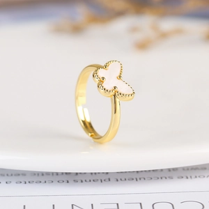 Macro shot of an adjustable gold-plated butterfly ring with white enamel detailing