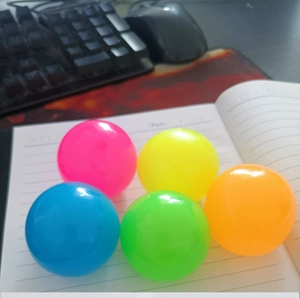 Groupe de cinq balles anti-stress lumineuses colorées sur un ordinateur portable poli