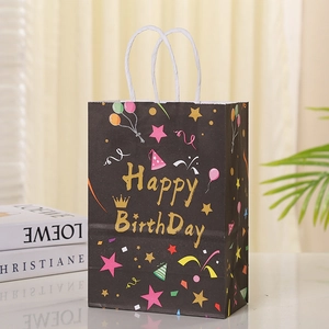 Detail view of a black birthday gift bag with golden Happy Birthday text and stars