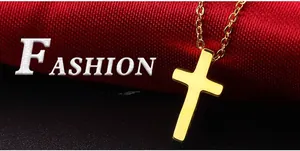 Macro shot of polished gold-plated cross pendant on a matching chain with red fabric background