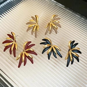 Detail view of 18k gold plated flower stud earrings in beige, burgundy, and black matte finish
