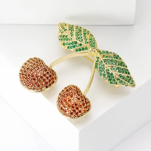 Elegant cherry brooch with gold alloy and micro-paved green and orange cubic zirconia