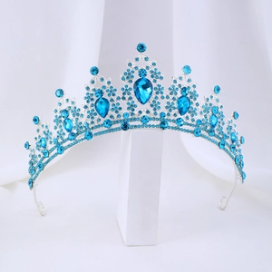 Detailed close-up of a silver bridal tiara with sparkling blue crystals and pear-shaped gems