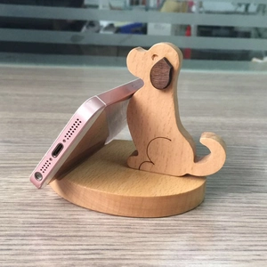 Macro shot of cute wooden dog-shaped smartphone stand on natural wood grain surface