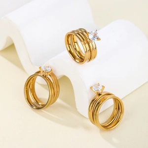Detailed view of three-piece gold plated stacking rings with round CZ prong setting