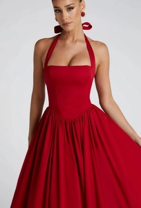 Dettaglio dell'abito rosso allacciato al collo con vita alta ed elegante gonna maxi