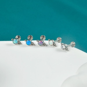 Macro detail of G23 titanium labret studs with opal and zircon in various vibrant colors