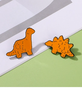 Dettaglio di spillette creative in smalto a forma di nugget di pollo dinosauro in lega arancione