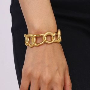 Gold stainless steel thick chain bracelet with textured and smooth links on a model's wrist