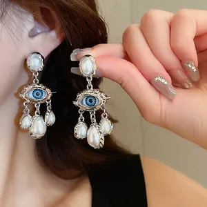 Vintage silver evil eye stud earrings with dramatic hammered frames and white teardrop pearls