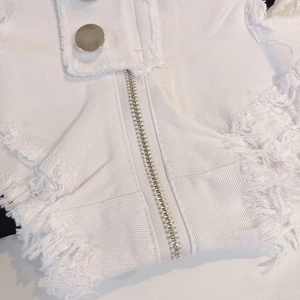 Detailansicht der weißen Denim-Shorts mit Metallreißverschluss und Fransensaum-Textur