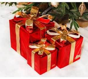 Detail of red Christmas gift boxes with gold bows and Merry Christmas lettering