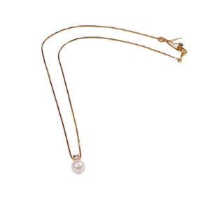 Classic gold necklace with round white pearl pendant and small sparkling zircon accent