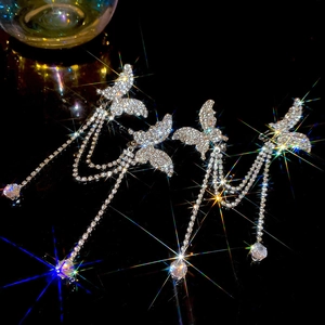 Funkelnde silberne Schmetterlings-Quastenohrringe mit Strass und Kristall auf schwarzem Grund