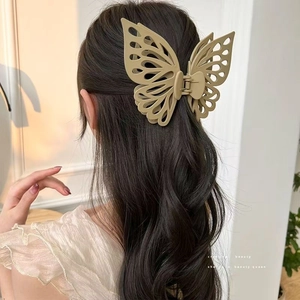Detailed back view of a khaki double-layered butterfly hair claw clip on brunette hair