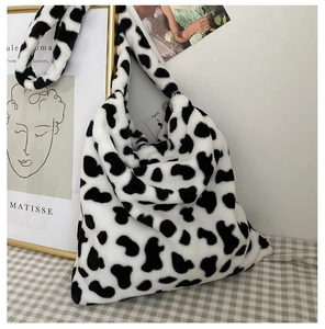 Detailed macro shot of soft cow print faux fur texture on a large capacity shoulder bag
