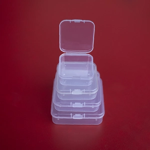 Detailed view of four nesting transparent PP plastic storage boxes on a red background