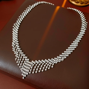 Detailed view of silver crystal tassel necklace with sparkling rhinestones on leather background