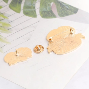 Detail of golden metal butterfly clutches and pin base with radial texture on a card