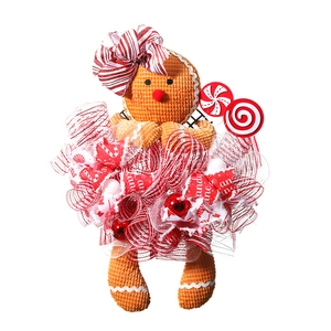 Christmas gingerbread man wreath decoration with red ribbons and festive candy cane motifs