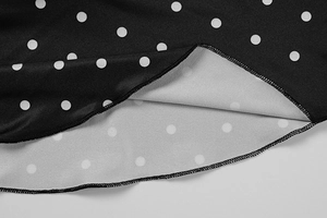 Detailed macro view of black and white polka dot fabric with high-quality stitching