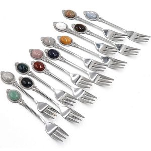 Set of 12 vintage metal spoons and forks with colorful gemstone handles on white background