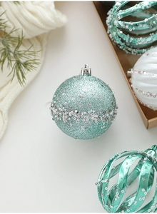 Detail of mint green and white Christmas balls with glitter on soft knit texture