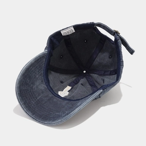 Navy blue washed cotton baseball cap with skull finger embroidery from a 45-degree angle