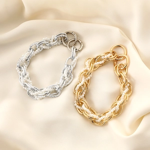 Elegant gold and silver metal bag chains with white pearls on beige silk fabric