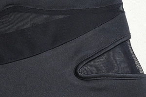 Close-up of black bodycon dress featuring breathable mesh patchwork and knit fabric details