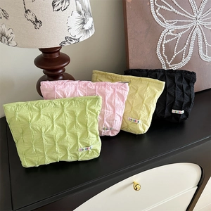 Detailed view of quilted bubble fabric makeup bags with zippers in four vibrant colors