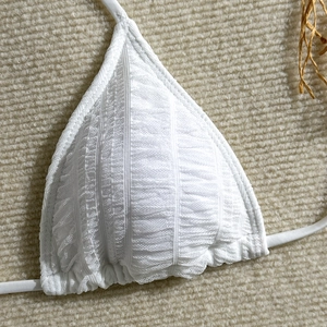 Detailed view of white ribbed bikini top with mesh texture and ruched edges