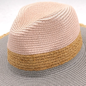 Dettaglio del cappello di paglia a tre colori con corona rosa e tesa grigia intrecciata