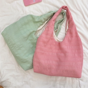 Detailed top view of pink and mint green seersucker tote bags with textured pleats