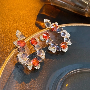Elegant C-shaped butterfly stud earrings with red and purple zircons on a gold base