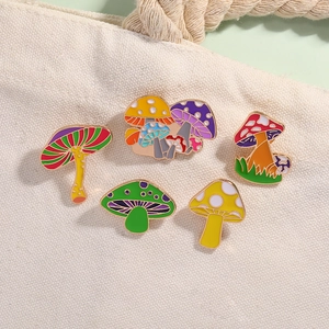 Detailed set of five colorful mushroom enamel pins on an off-white canvas bag surface