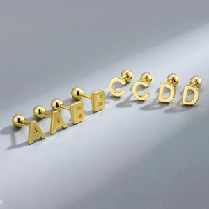 Macro view of gold-plated stainless steel letter earrings A, B, C, and D with polished finish