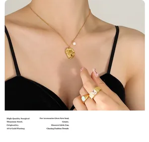 Macro detail of 18k gold plated titanium steel necklace with pearl and abstract pendant
