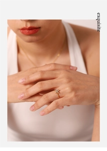 Dettaglio squisito di un anello a fiore dorato con cristalli sulla mano di una modella