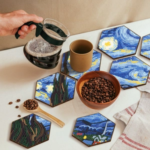 Macro detail of hexagonal wooden coasters with Starry Night diamond art and coffee props
