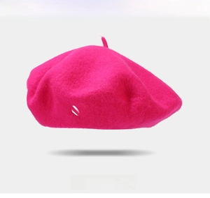 Detail of rose red beret showing soft wool texture and white heart embroidery detail