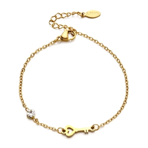 Close-up of a gold stainless steel bracelet featuring a heart key charm and a clear zircon
