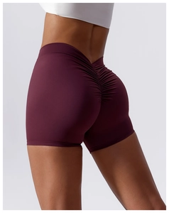 Detail of high waist yoga shorts with scrunch butt lifting seam in burgundy fabric