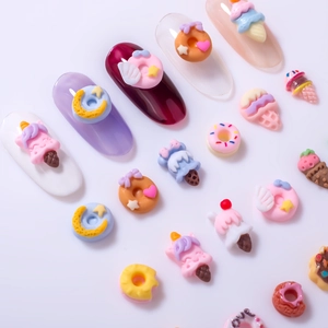 Macro shot of 3D resin nail art charms in colorful donut and ice cream dessert shapes