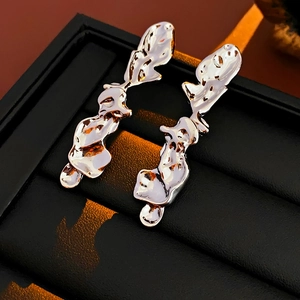 Detailed view of silver irregular lava fluid earrings on a black leather jewelry box