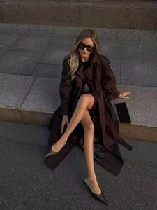 Détail d'un long trench-coat marron foncé avec ceinture et revers sur un mannequin