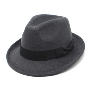 Detail of a charcoal grey fedora hat with a black satin ribbon and bow on white background