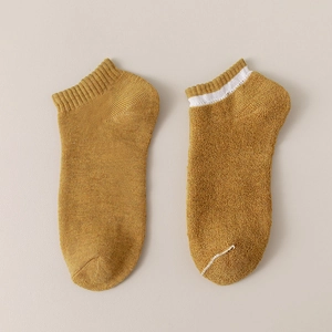 Mustard yellow cotton ankle socks with solid and white striped designs in a flat lay view