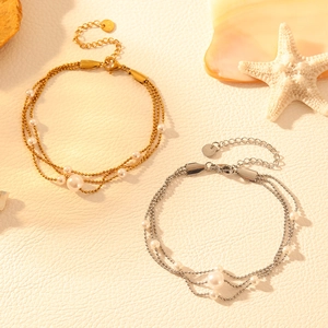 Three-layer stainless steel bracelet with nine pearls in gold and silver finishes