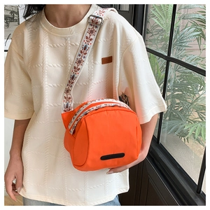 Detail of orange nylon crossbody bag with ethnic embroidered wide shoulder strap